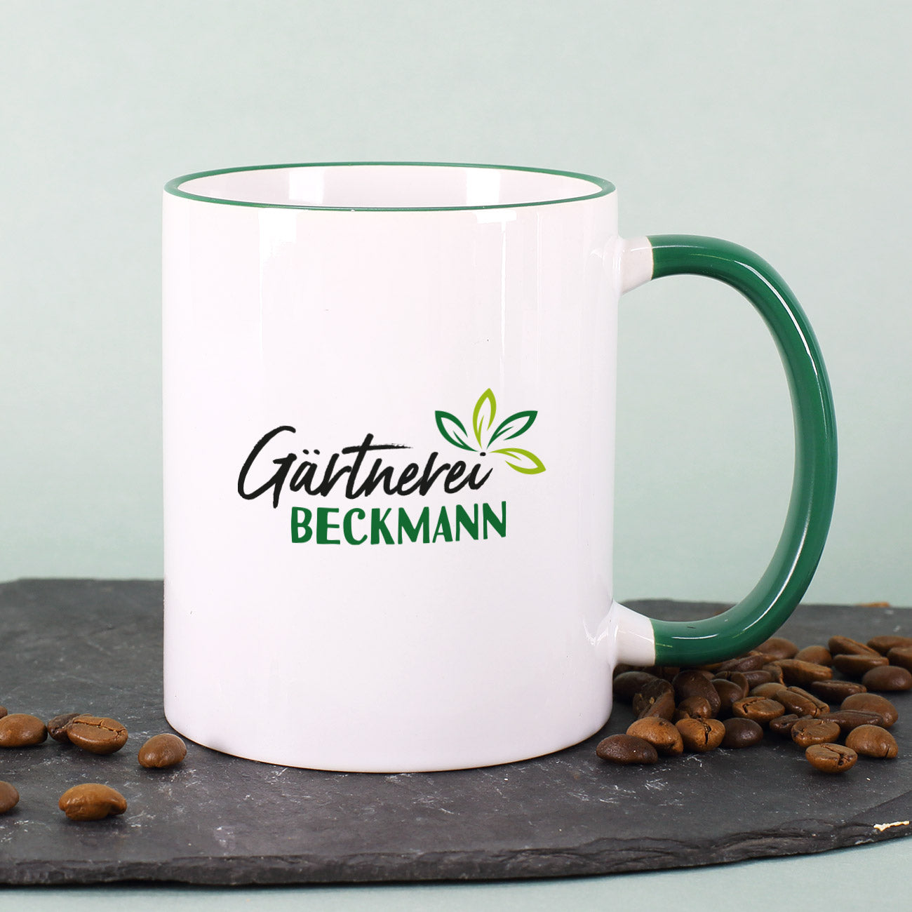 Personalisierte Kaffeetasse mit Firmenlogo – Weiß mit grünem Rand & Henkel – geschenke-online.de B2B Shop