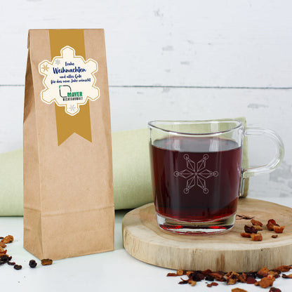 Set aus Tee und einem passenden Glas mit Schneeflocken-Motiv und Logo