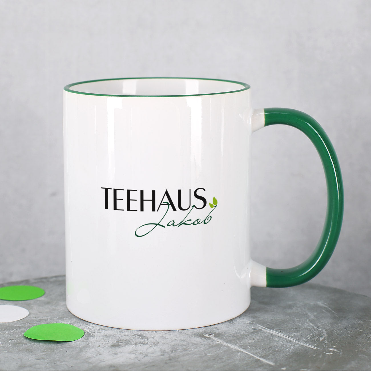 Tasse mit dunkelgrünem Rand und Henkel inkl. Druck des Logos