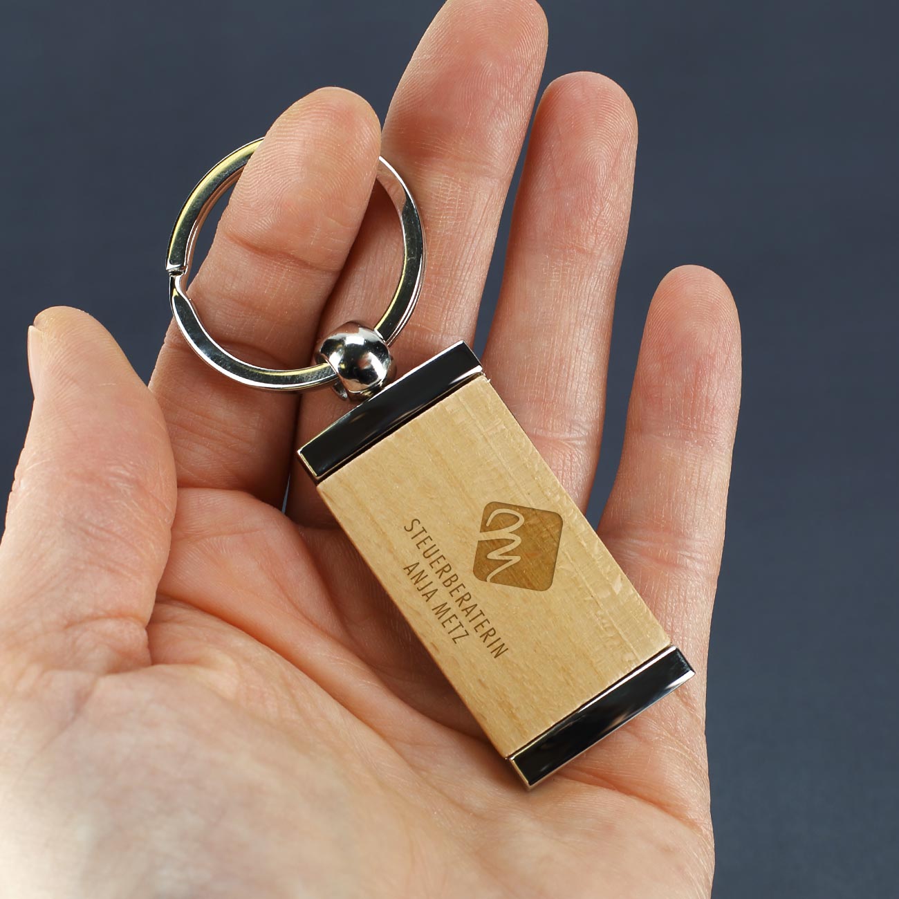 Metall Schlüsselanhänger mit graviertem Holzeinsatz und eigenem Firmen- und Unternehmenslogo Beispiel Steuerbüro hochkant